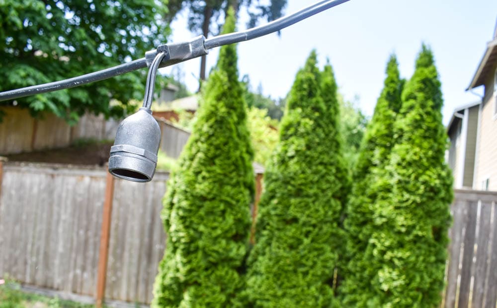 close-up of emply string light socket hanging over a patio, ready for a light bulb to be inserted