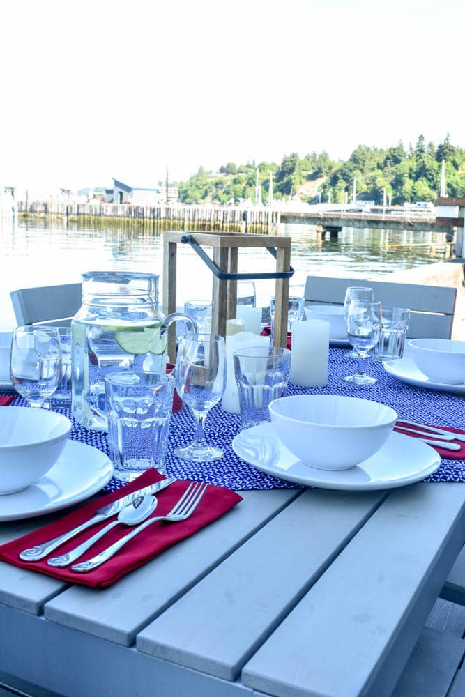 4th of July table set for a dinner party with red white and blue decorations on the waterfront