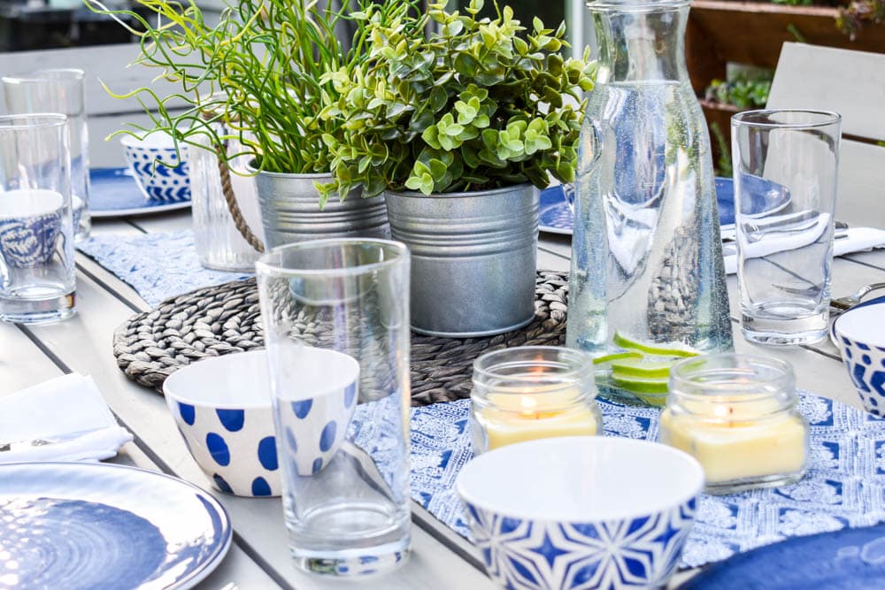 This simple and budget-friendly dining patio makeover transforms a small ugly concrete slab patio into a beautiful outdoor dining room. There's a vertical garden, string lights, an outdoor rug, and more!