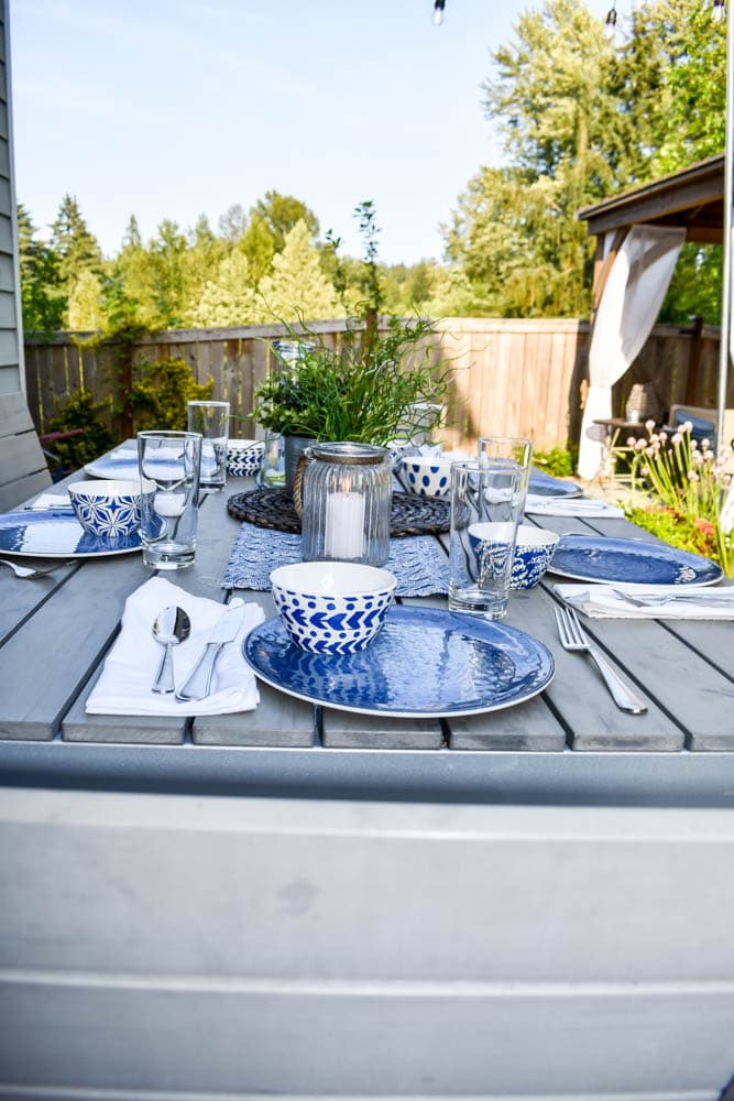 This simple and budget-friendly dining patio makeover transforms a small ugly concrete slab patio into a beautiful outdoor dining room. There's a vertical garden, string lights, an outdoor rug, and more!