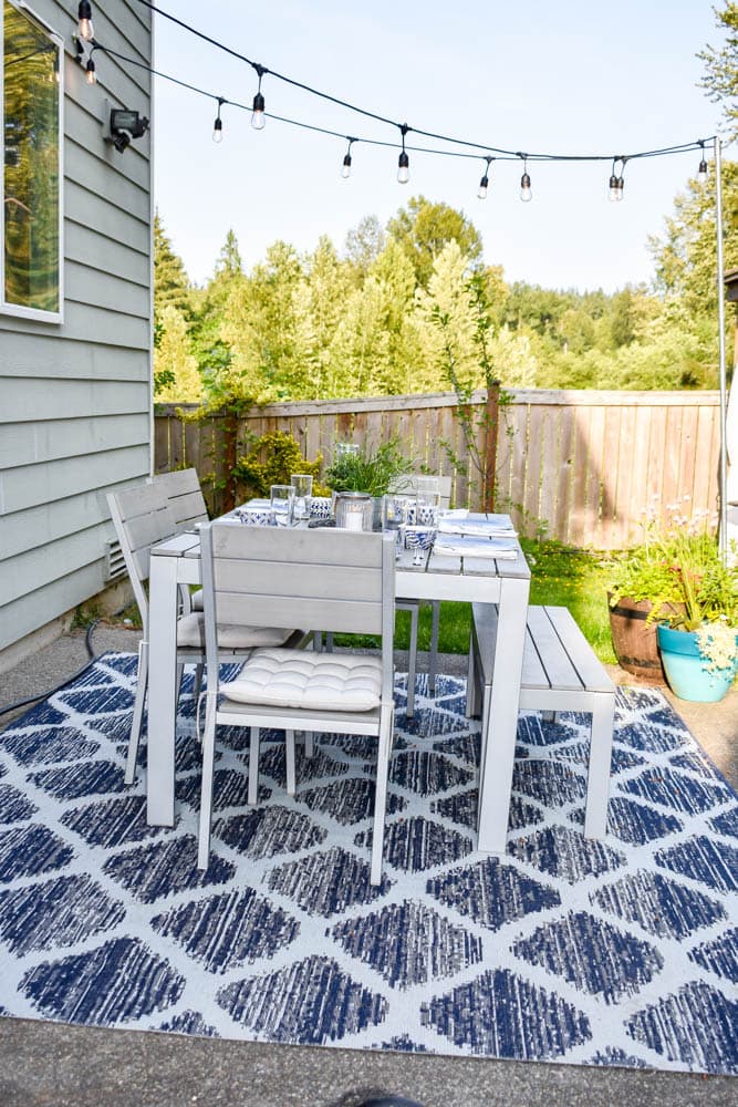 patio with outdoor dining set and string lights hung from diy string light poles