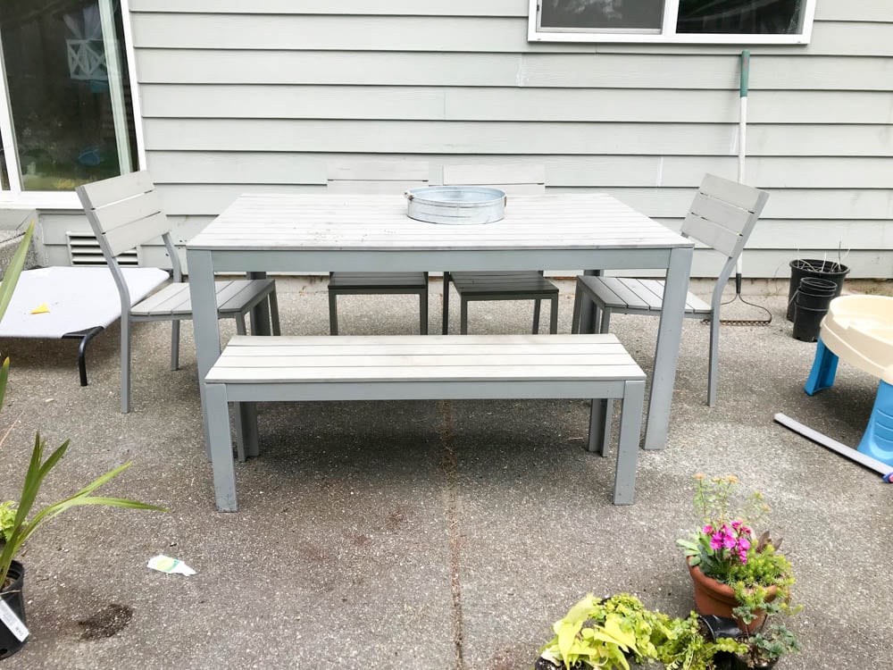 This simple and budget-friendly dining patio makeover transforms a small ugly concrete slab patio into a beautiful outdoor dining room. There's a vertical garden, string lights, an outdoor rug, and more!