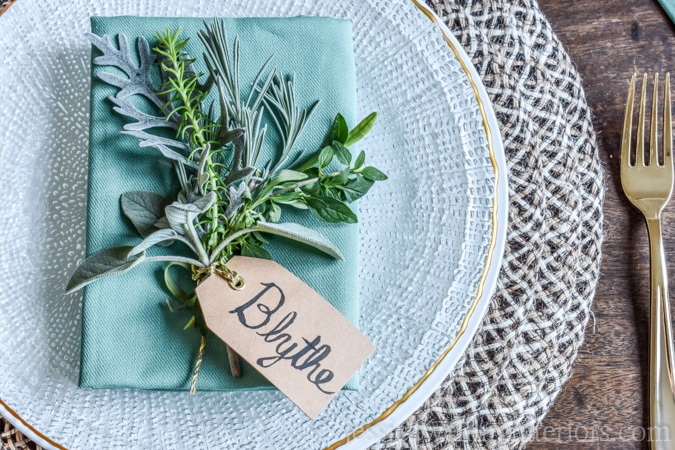 photo of holiday place setting with simple place card holder and fresh herbs