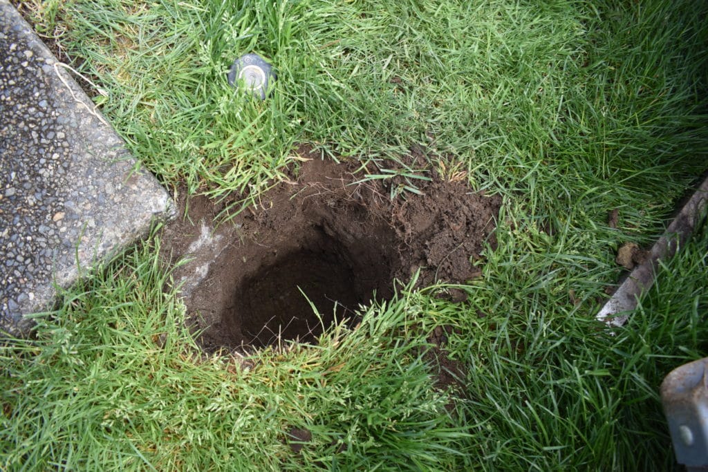 close-up of hole dug for a string light pole with PVC pipe