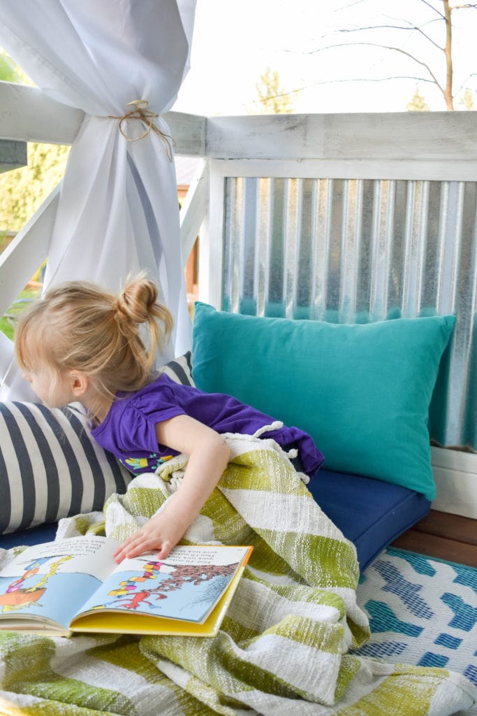 image of inside of playhouse with child reading in reading nook