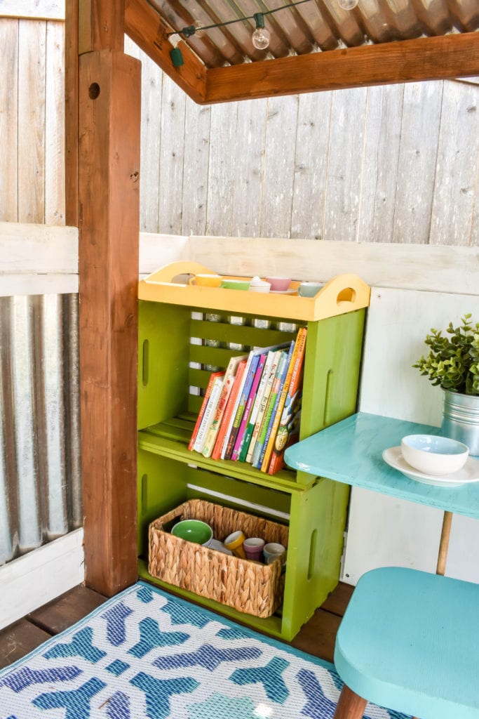 image of playhouse with bookshelves and mini dining table and chairs.