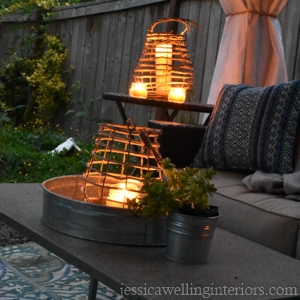 nighttime photo of outdoor living room with glowing candle lanterns