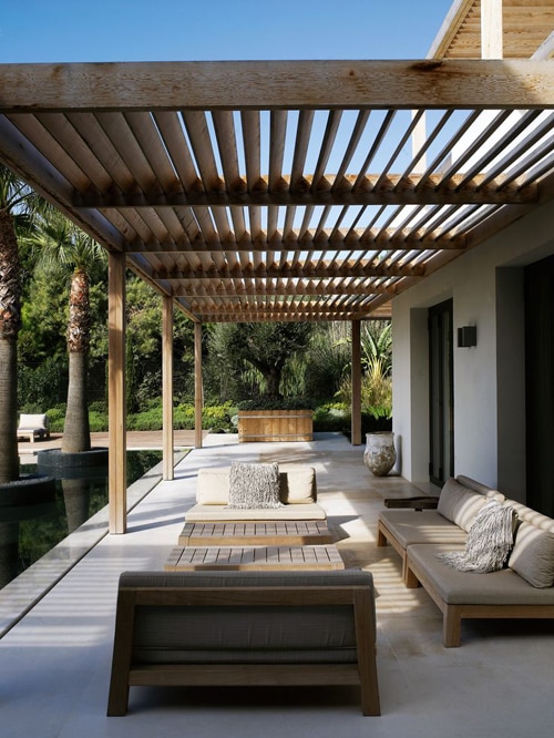 modern pergola structure patio shade idea with outdoor sofa and palm trees