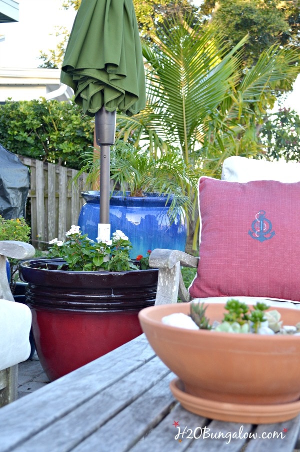 patio seating area with DIY planter umbrella stand and umbrella