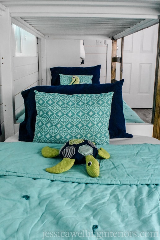 view of two bottom bunks with homemade stuffed sea turtle and seahorse on the beds