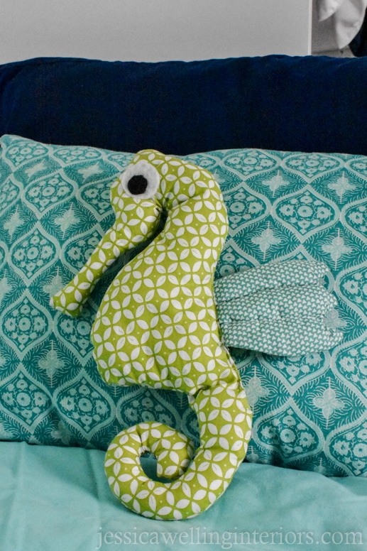 hand made stuffed seahorse toy on a child's pillow on a bunk bed