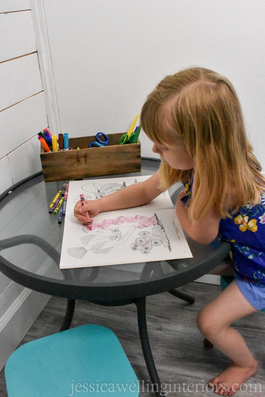 child coloring at a kids table