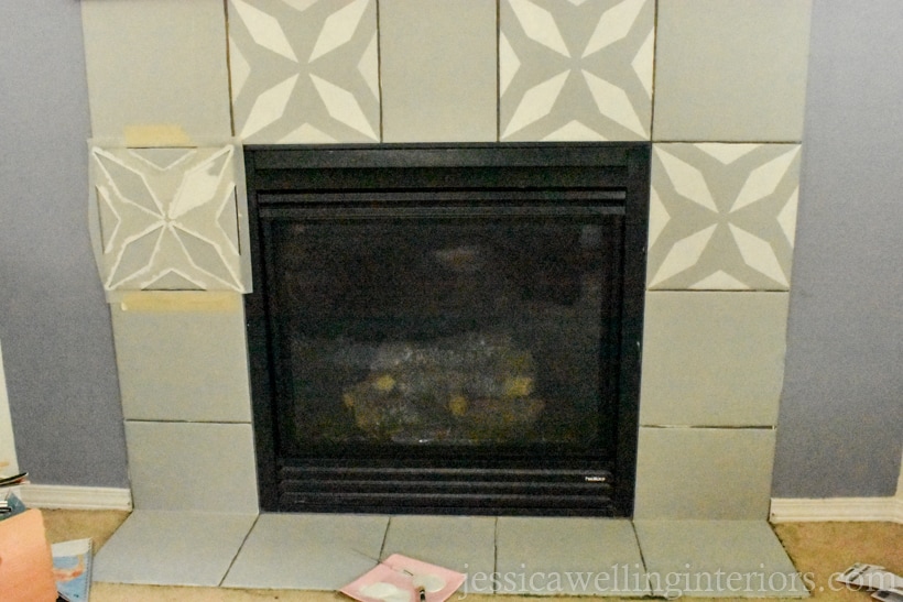 gas fireplace with surrounding tiles painted and a few of the tiles have been painted with a faux cement tile stencil