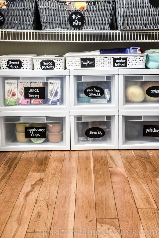 bottom half of pantry with white plastic drawers with chalkboard sticker labels- "juice boxes," "nut-free snacks", etc.