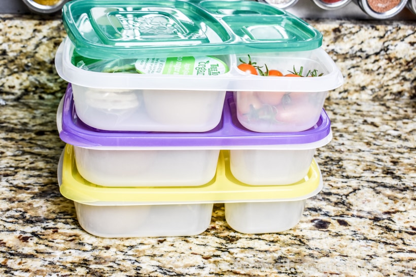 stack of three bento lunch containers packed on kitchen countertop