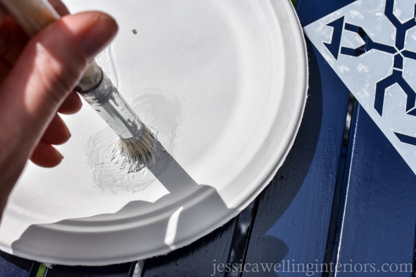 close-up of stencil brush being swirled on a paper plate before applying to stencil for painting