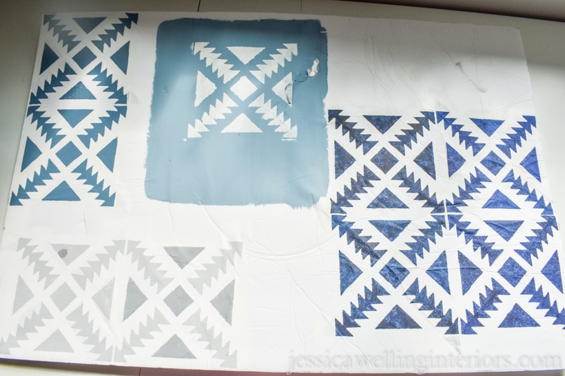 white cardboard test piece with painted Aztec stencil in differing shades of blues and grey