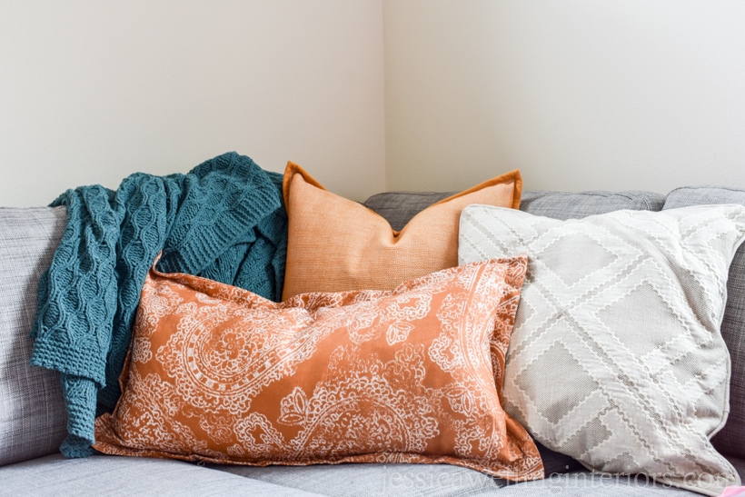 Fall living room decor with grey sofa, teal throw blanket, yellow and orange throw pillows