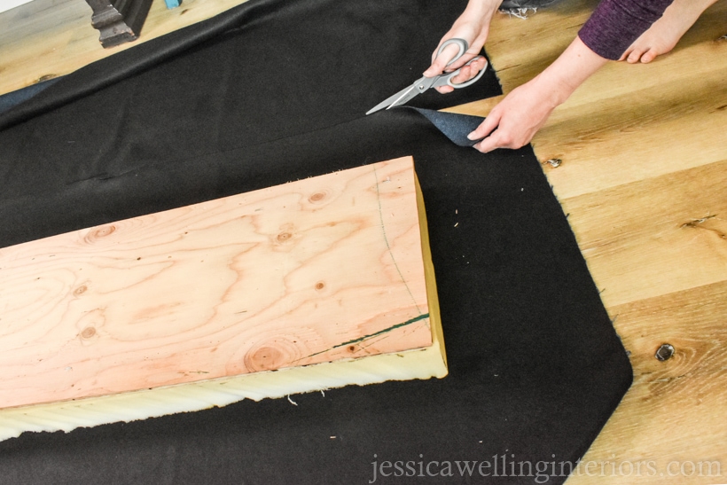 hand cutting navy blue upholstery fabric to size for DIY upholstered bench cushion