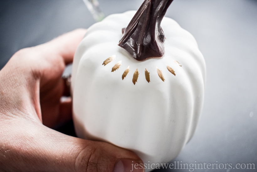 white pumpkin being painted with gold leaf paint for Fall decor ideas