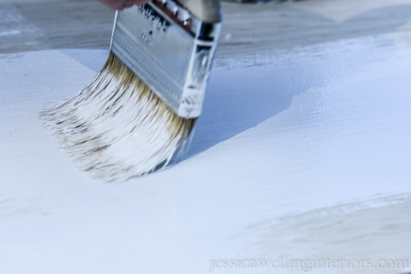 close-up of paintbrush applying BIN primer to top of DIY floating desk