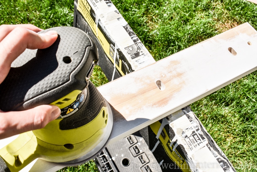 modern coat hooks rack on sawhorses being sanded with an orbital sander