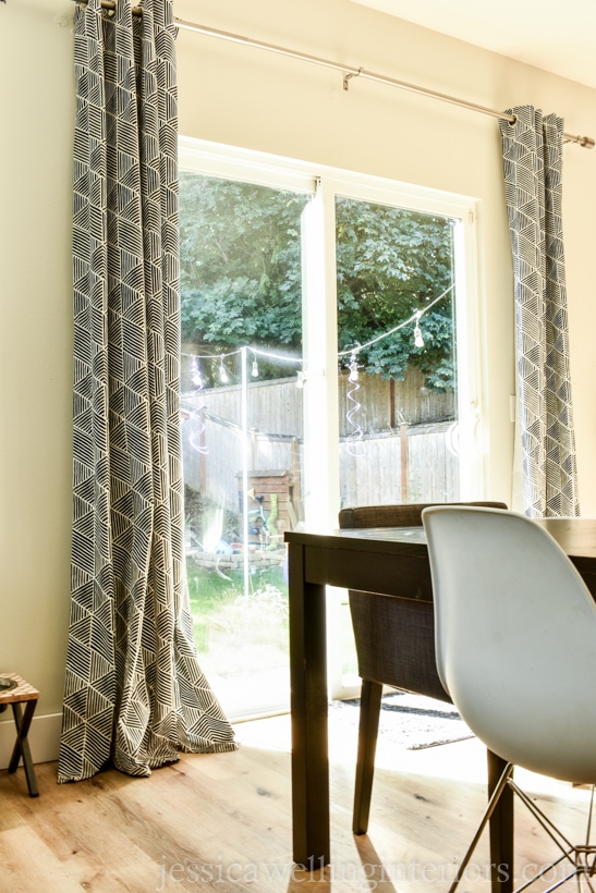 Before: image of cheap curtain panels from Ikea hanging on sides on sliding glass door with dining table and chairs in foreground