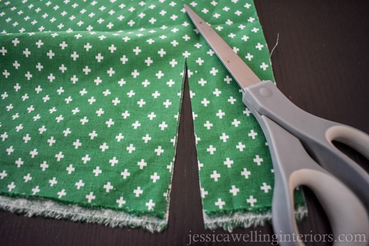 green cotton quilting fabric with plus sign pattern in white, being cut into 1.5" strips