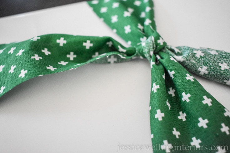 green fabric "ribbon" bow being adjusted