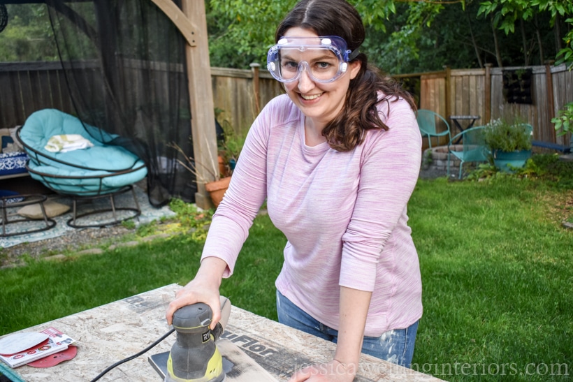 woman using Ryobi orbital sander in backyard