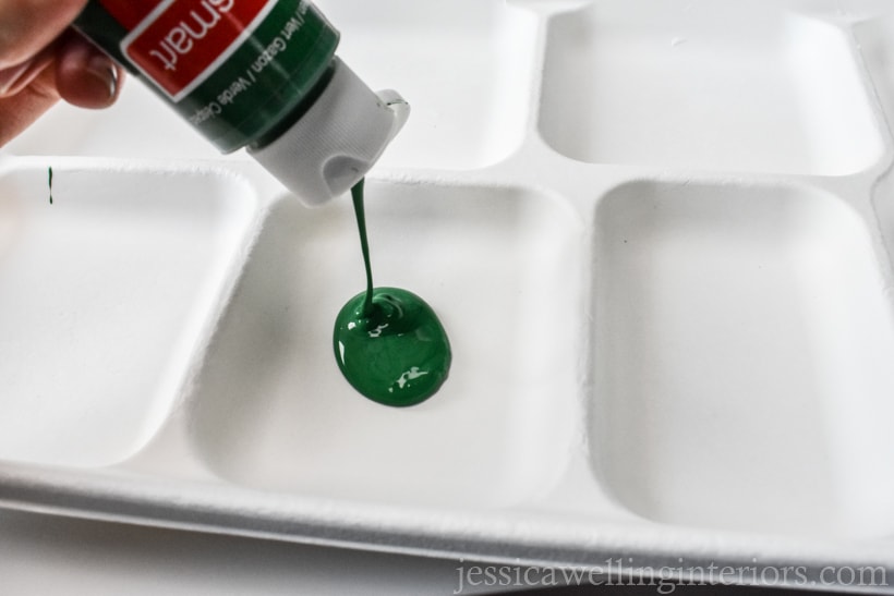 green acrylic paint being poured onto a paper plate