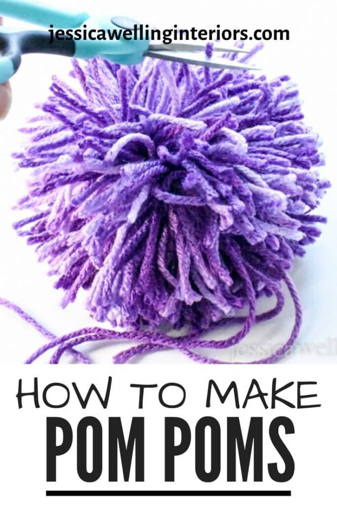 How to Make a Pom Pom: close-up of large purple yarn pompom being trimmed with craft scissors