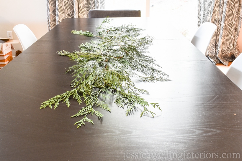 table with evergreen cedar brnaches spread across it