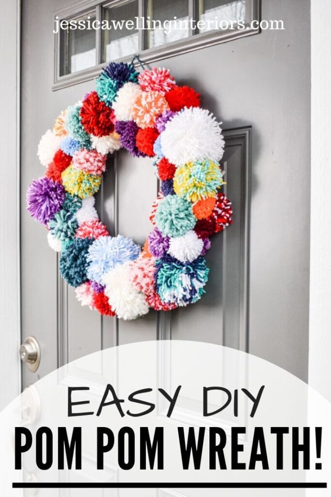 Easy DIY Pom Pom Wreath!: multi-colored wreath made of yarn pom poms on a front door for Christmas