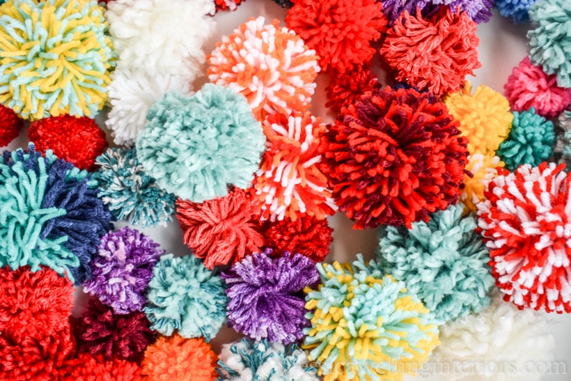 pile of colorful yarn pom poms in a variety of sizes