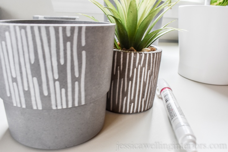 close-up of modern grey pot with white vertical line pattern partially finished