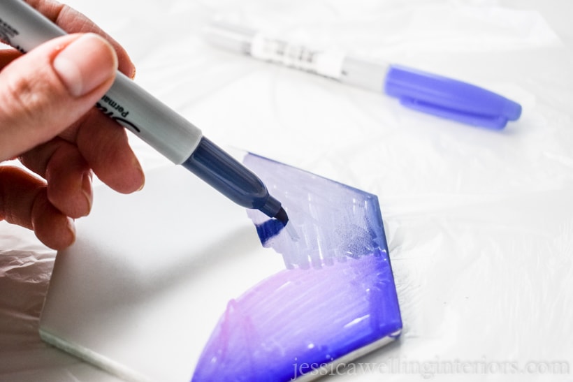 close up of hand drawing on white tile with a navy blue Sharpie in a tile coaster tutorial