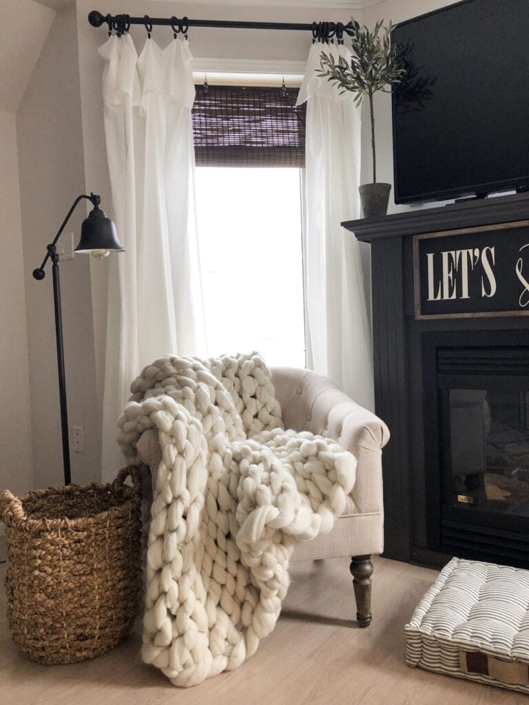 cozy reading chair placed in front of a bright window to maximize natural light in a dark room