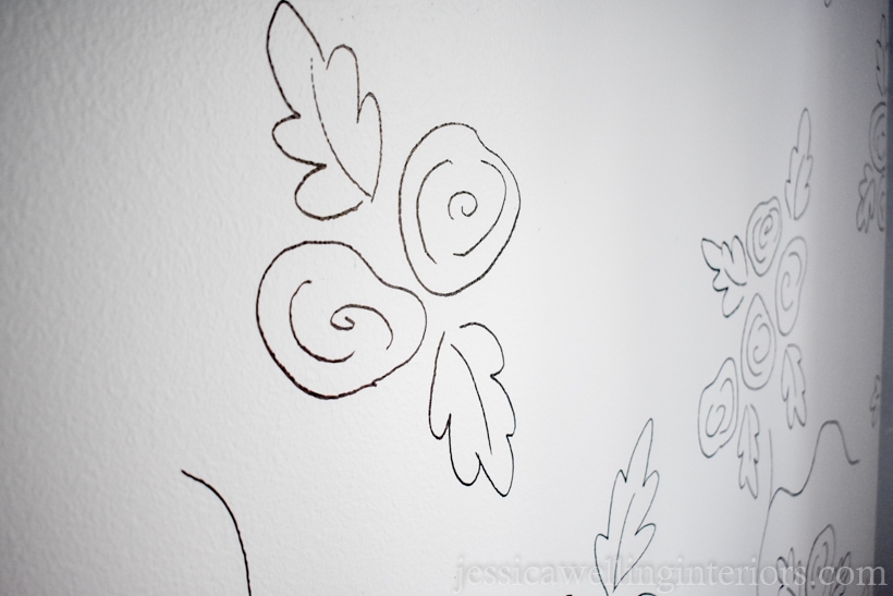 white wall with large roses drawn in black lines to resemble wallpaper