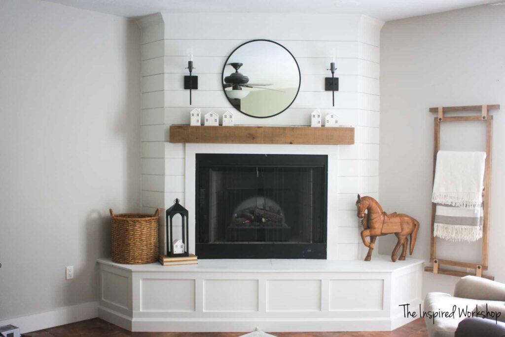 view of living room fireplace, brightened up with white paint and a large mirror above the mantel