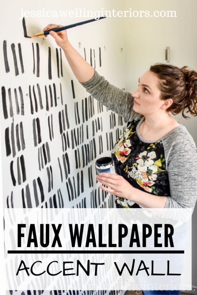 Faux Wallpaper Accent Wall: woman painting black brush strokes on a white wall to create a modern patterned accent wall