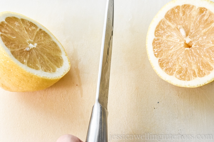 knife cutting a lemon in half to prep it for printing tea towels