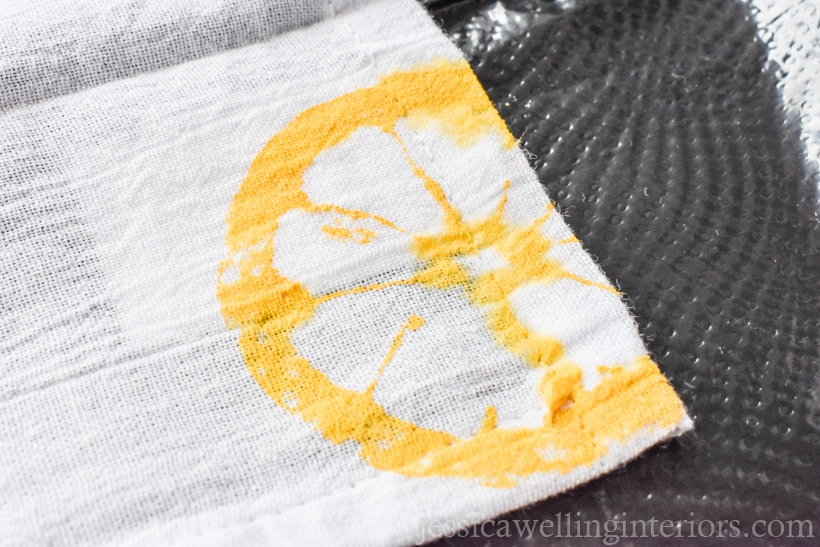 close-up of white dish towel with yellow lemon printed on the corner