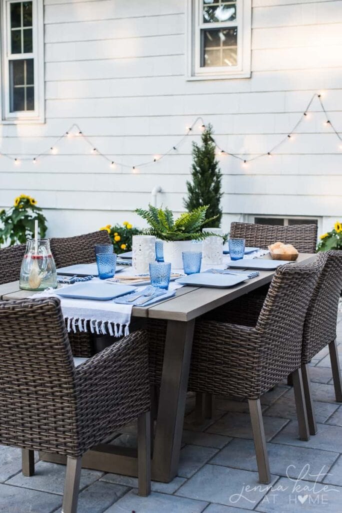 patio dining table with string lights draped in the background