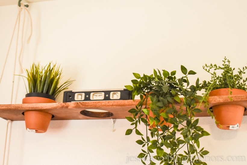 wood vertical garden shelf being measured with a level