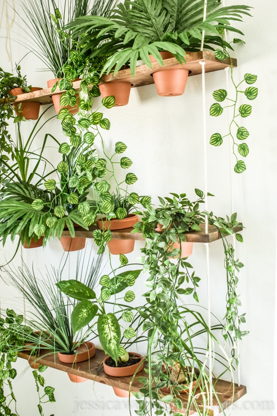 side angle view of DIY vertical garden with terra cotta pots and indoor hanging plants