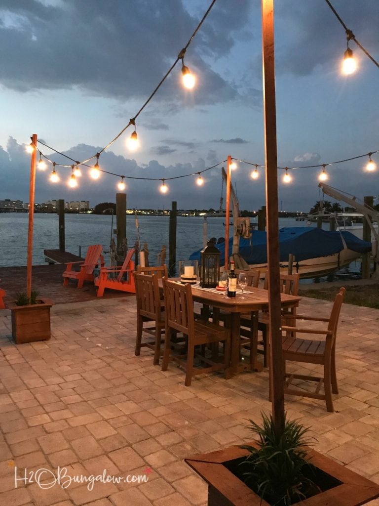 waterfront patio with DIY string light poles in planter boxes