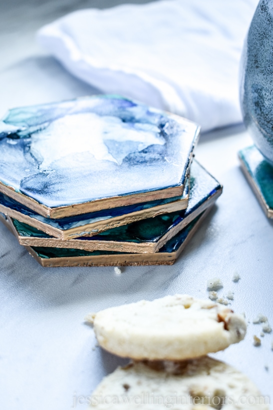 stack of DIY coasters with cookies in the foreground