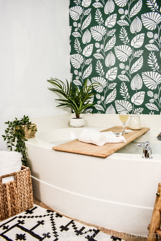 bathtub in front of a green botanical stenciled accent wall