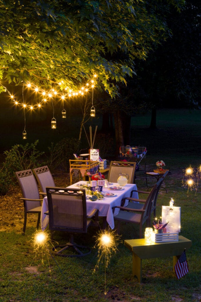 summer party with string lights draped through tree branches overhead